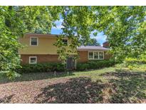 Two-story home showcasing a brick and siding exterior with mature shade trees at 2010 Summerdale Dr, Raleigh, NC 27604