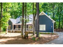 Charming blue two-story home featuring a welcoming front porch and mature landscaping with a wooded setting at 206 Lilliput Ln, Wake Forest, NC 27587