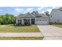 Charming single-story home featuring a well-manicured lawn and attached two car garage at 3034 Raddercrest Ct, Fuquay Varina, NC 27526
