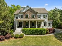 Charming two-story home featuring a stone facade, covered porch, and well-maintained landscaping at 3913 Orchard Point Ct, Apex, NC 27539