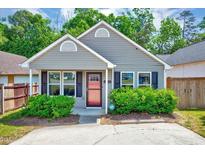 Charming one-story home with well-maintained landscaping and an inviting red front door at 4114 Sudbury Rd, Durham, NC 27704