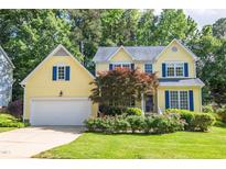 Charming yellow two-story home featuring blue shutters and a well-manicured front lawn at 5417 Harrington Grove Dr, Raleigh, NC 27613