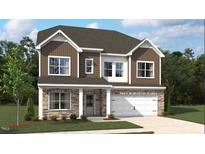Charming two-story home featuring a stone facade, brown siding, white trim, and an attached two car garage at 556 Jocund St # 13, Rolesville, NC 27571