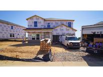 New two-story home under construction featuring Tyvek HomeWrap and materials on site at 676 White Birch Ln, Angier, NC 27501