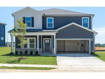 Charming two-story home with attached two-car garage and well-manicured lawn at 676 White Birch Ln, Angier, NC 27501