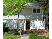 Charming townhouse with a white fence, mature landscaping, and welcoming front entrance at 7177 Sandy Creek Dr, Raleigh, NC 27615
