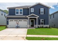 Charming two-story home featuring blue siding, white trim, and an attached two-car garage at 749 Deschutes Dr, Garner, NC 27529