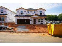New two-story home under construction featuring Tyvek house wrap, attached garage, and situated in a developing neighborhood at 761 Deschutes Dr, Garner, NC 27529