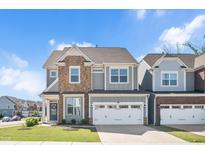 Charming two-story home boasts stone accents, a two-car garage, and a well-manicured lawn at 101 Rostova Way, Holly Springs, NC 27540