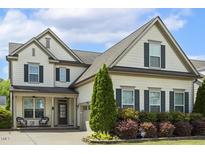 Charming two-story home with inviting front porch and well-manicured landscaping at 121 Martingale Dr, Holly Springs, NC 27540