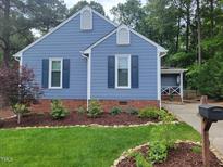 Charming blue house featuring dark blue shutters and nicely landscaped yard at 1304 Greenside Dr, Raleigh, NC 27609