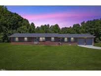 Charming single-story brick home with an attached two-car garage and well-manicured front lawn at 137 Vaiden Rd, Louisburg, NC 27549