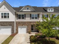 Charming townhome with stone accents, a single-car garage, and a well-maintained front yard at 1394 Southpoint Trl, Durham, NC 27713
