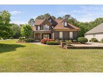 Stunning two-story home featuring stone and siding, a well-manicured lawn, and beautiful landscaping at 1508 Samuel Wait Ln, Wake Forest, NC 27587