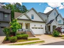 Charming two-story home featuring a covered porch, brick accents, well-maintained landscaping, and a two-car garage at 151 Monteith Dr, Chapel Hill, NC 27516