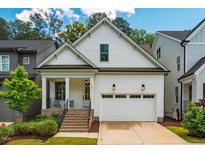 Charming home with white siding, well-manicured lawn, and a welcoming two-car garage at 151 Monteith Dr, Chapel Hill, NC 27516