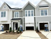 Charming townhomes feature light gray siding, white trim, and attached garages at 166 Ripple Way # 323, Clayton, NC 27520
