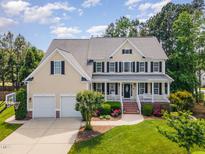Charming two-story home with a welcoming front porch, beautiful landscaping, and a two car garage at 1952 Combine Cir, Apex, NC 27502