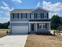 Two-story home featuring a two-car garage, a black front door, and double-hung windows under a blue sky at 24 Grove Township Way, Angier, NC 27501