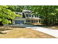 Inviting two-story home with blue shutters, a welcoming front porch, and a spacious driveway at 25 Ballinger Dr, Youngsville, NC 27596