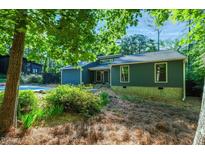Charming single-story home featuring a blue exterior, manicured landscaping, and natural light at 2511 Bexley Ave, Durham, NC 27707