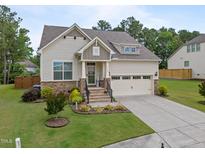 Charming single-Gathering home with a well-manicured lawn, stone accents, and a two-car garage at 302 Kinney Glenn Ct, Durham, NC 27713