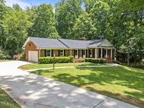 Charming brick home with manicured lawn, black shutters and a welcoming front porch at 3204 Manor Ridge Dr, Raleigh, NC 27603