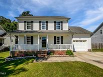 Charming two-story home featuring a welcoming front porch, attached garage, and well-maintained lawn at 3708 Mackinac Island Ln, Raleigh, NC 27610