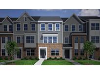 Charming townhome featuring a brick facade, gray siding, and well-manicured lawn at 372 Chesapeak Commons St # 131, Garner, NC 27529