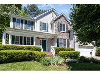 Charming two-story home featuring a welcoming front porch, stone accents, and lush landscaping at 4608 Regency Dr, Durham, NC 27713