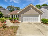 Charming home featuring a two-car garage, well-manicured landscaping, and a beautiful flower bed at 5612 Tealbrook Dr, Raleigh, NC 27610