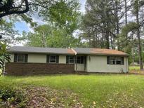 Ranch home with horizontal siding, brick facade, and a mature tree line at 601 Crestview Dr, Durham, NC 27712