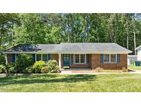 Charming brick home with well-maintained landscaping and blue shutters at 612 Harvest Ln, Raleigh, NC 27606