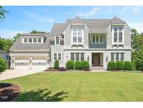 Beautiful home with a well-manicured lawn, white brick and gray shingle siding, and a two-car garage at 6502 New Market Way, Raleigh, NC 27615