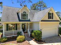 Charming two-story home with a landscaped front yard, covered porch, and attached two-car garage at 6513 Cablewood Dr, Raleigh, NC 27603