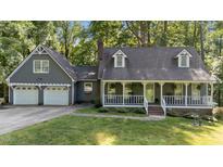 Charming home with a welcoming front porch and two-car garage nestled among lush greenery at 6517 Hidden Pond Rd, Wendell, NC 27591