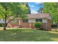 Charming brick home featuring mature trees and a well-maintained front yard at 717 Fairfield St, Burlington, NC 27215