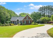 Charming brick home boasts a well-manicured lawn and a winding driveway in a beautiful neighborhood at 8733 Crowder Rd, Raleigh, NC 27603