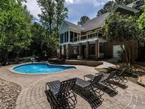 Beautiful backyard pool area with a fountain, lounge chairs, and mature landscaping creating a private oasis at 91 E Walker Woods Ln, Clayton, NC 27527