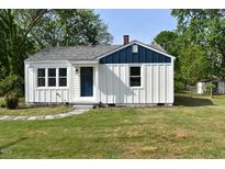 Charming home featuring white siding, a blue accent, and a well-manicured lawn at 102 Allen St, Graham, NC 27253