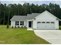 Charming single-Gathering home featuring a two-car garage, well-manicured lawn, and classic architectural details at 107 Earnest Way, Kenly, NC 27542