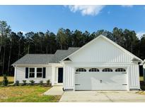 Charming single-Gathering home featuring a two-car garage, landscaped yard, and classic exterior design at 107 Earnest Way, Kenly, NC 27542