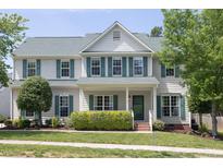 Charming two-story home featuring light siding, green shutters, a manicured lawn and mature landscaping at 110 Stoney Dr, Durham, NC 27703