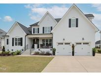 Beautiful white brick home with a covered porch and two-car garage, offering curb appeal at 1180 Duke Farm Dr, Wake Forest, NC 27587