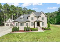 Stately brick home featuring manicured landscaping, a welcoming entrance, and attached garage at 120 Lu Tom Ln, Wendell, NC 27591