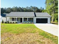 Charming single-story home boasts a well-manicured lawn and an attached two-car garage at 121 Earnest Way, Kenly, NC 27542