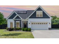 Charming two-story home featuring a mix of siding, stone accents, and a well-manicured lawn at 123 Jonalker Ct, Clayton, NC 27520