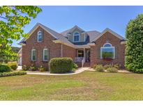 Beautiful brick home featuring manicured landscaping, arched windows and a welcoming front porch at 130 Skipwith Dr, Wendell, NC 27591
