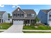Charming two-story home featuring stone accents, a two-car garage, and professionally landscaped front yard at 1305 Addison Lake St, Fuquay Varina, NC 27526