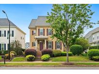 Charming two-story home featuring a well-manicured lawn, mature landscaping, and a welcoming front porch at 1328 Palace Garden Way, Raleigh, NC 27603